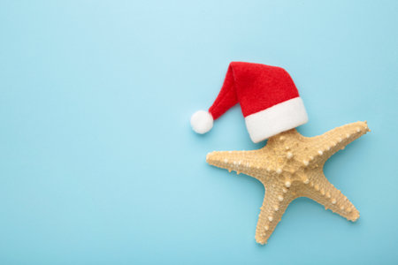 Santa Claus hat on starfish on blue background. Top view.の写真素材