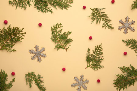 Thuja branches and viburnum and christmas decoration on beige background.