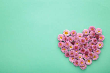 Heart with pink flowers on mint background. Spring