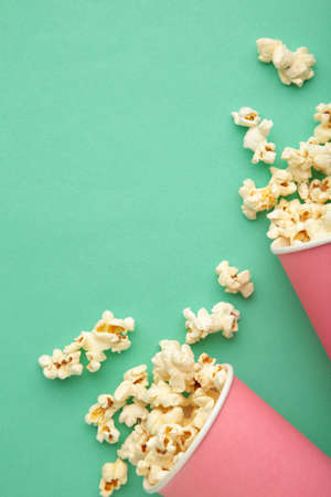 Popcorn in pink cups. Three cups of popcorn on mint background. Sweet popcorn. Top viewの写真素材
