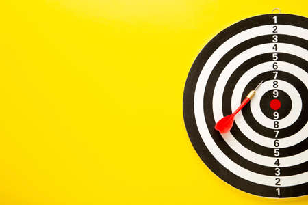 Dart board with red darts on yellow background. Top view.の写真素材