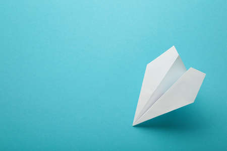 White paper airplane on a blue background. Top viewの写真素材