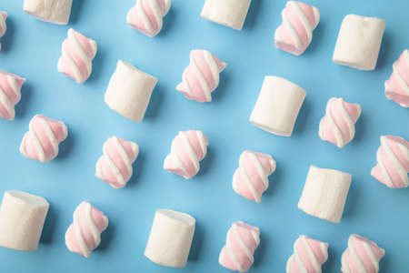 White and pink marshmallow on blue background. Pastel creative textured pattern. minimal. Top viewの写真素材
