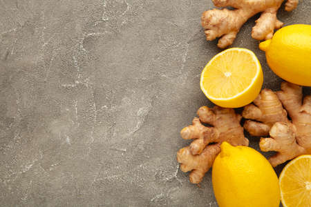 Fresh ginger with sliced and lemon on gray background. Top viewの写真素材