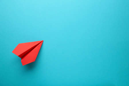 Red paper airplane on a blue background. Top viewの写真素材
