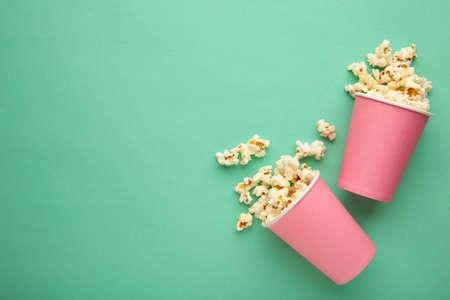 Popcorn in pink cups. Three cups of popcorn on mint background. Sweet popcorn. Top viewの写真素材