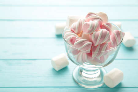 Marshmallow in bowl on blue background. Sweet food dessert. Top viewの写真素材