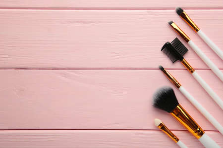 Set of makeup brushes on pink wooden background. Top view.の写真素材
