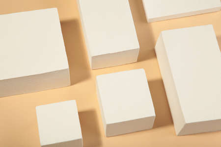 White square podiums on beige background. Trend fashion showcase for cosmetic products, goods, shoes, bags, watches. Top viewの写真素材