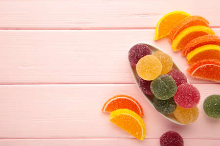 Jelly sugar candies in glass bowl on pink background. Top viewの写真素材