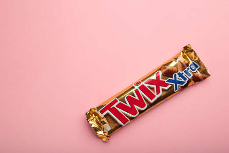 Long milk chocolate bars with caramel filling on pink background. Twix. Nikolaev, Ukraine - December...