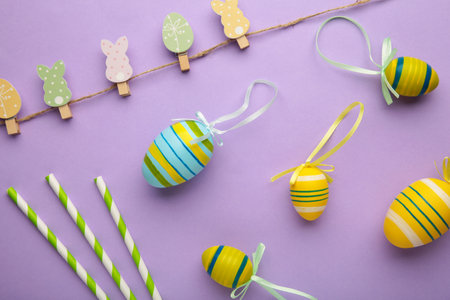 Easter eggs with decoration on purple background with copy space. Top view