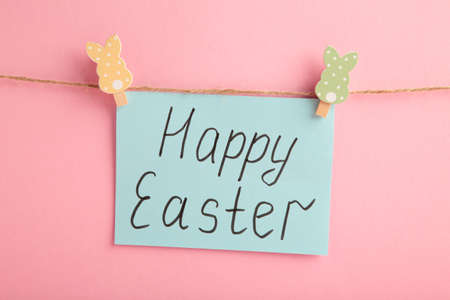 Inscription Happy Easter on gray background, a rope with clothespins. The concept of postcards for the Easter holiday. Top viewの写真素材