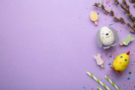 Easter holiday concept with cute handmade eggs, chicks and bunny on purple background. Top view....