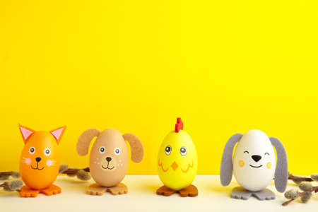 Easter holiday concept with cute handmade eggs, dogs, chicks and cat on yellow background. top view. happy easterの写真素材