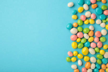 Colorful chocolate candy pills withs space on blue background. top viewの写真素材