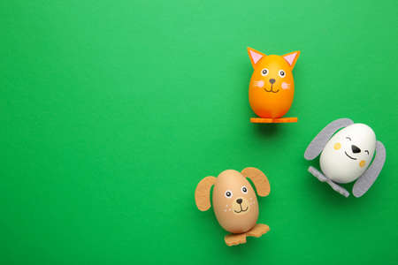 Easter holiday concept with cute handmade eggs, dogs and cats on green background. top view. Happy...