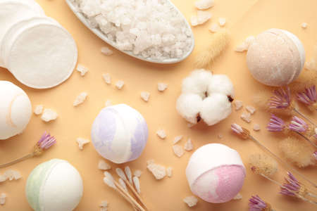 Aroma bath bombs in spa composition with dry flowers and salt on beige background. top viewの写真素材