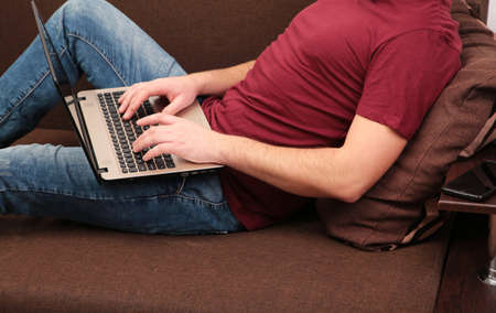 Businessman working at home with a laptop on sofa. top viewの写真素材