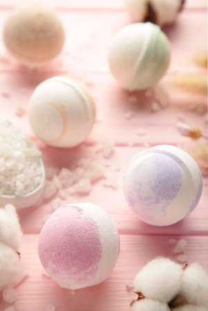 Aroma bath bombs in spa composition with dry flowers and salt on pink background. top viewの写真素材