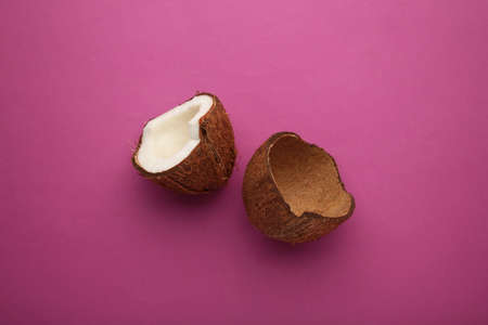 Coconut on a pink background. Halves and whole coconuts.の写真素材