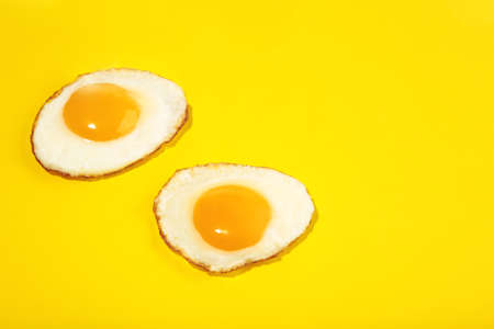 Two flawless frie egg on the yellow background. top view.の写真素材