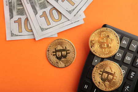 Bitcoin coin and cash with calculator on orange background. top view