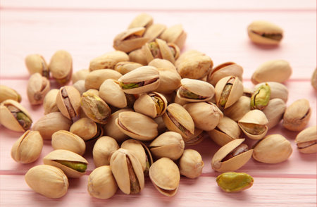 Pile of Pistachios on the pink background. top view.