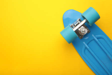 Penny Skate board blue with blue wheels on yellow background. top view