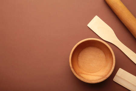 Wooden kitchen utensils on brown background. top viewの写真素材