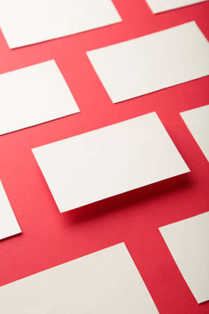 Mockup of horizontal business cards stacks arranged in rows on red paper background. top viewの写真素材