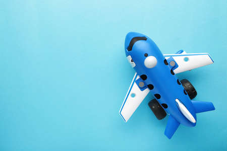 Plastic toy plane on blue background with space for text. top viewの写真素材