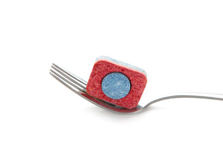 Dishwasher tablet on a fork isolated on a white background. top view.