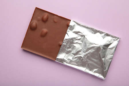 Chocolate wrapped in foil, clipping path on purple background. top view
