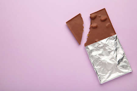 Bitten Chocolate bar in foil on purple background. With clipping path. top viewの写真素材