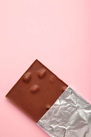Chocolate wrapped in foil, clipping path on purple background. top view