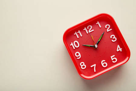 Red wall clock on gray background. top view