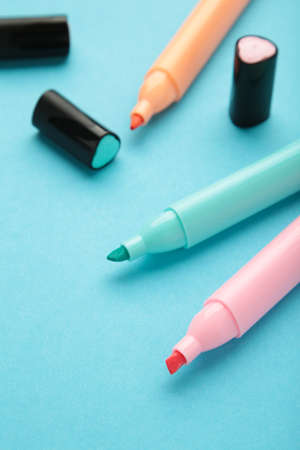 Open markers and space for text on blue background. Pink, blue and orange highlighters