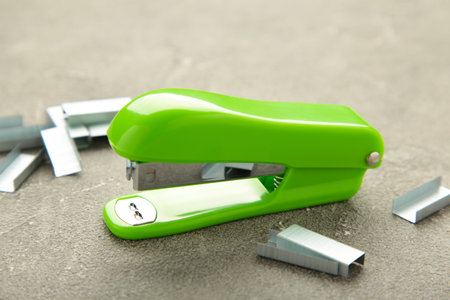 lGreen stapler on gray background. top view. school supplies
