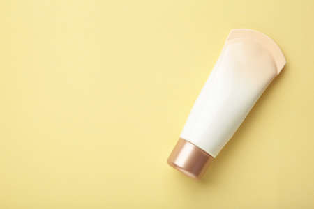 Tube of cream or gel white plastic product on beige background. top view. Space for text