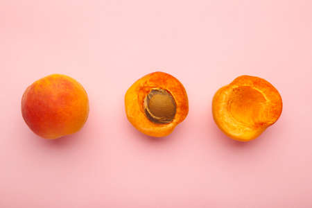Fresh tasty apricots on pink background, top viewの写真素材