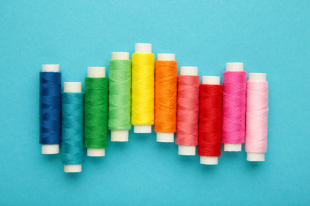 Color sewing threads on blue background. Space for text. top view