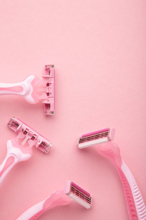 Pink razor on pink background close up. Vertical photo