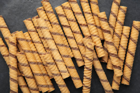 Close-up of striped wafer rolls on dark background. background or textureの写真素材