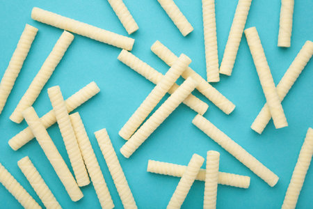Delicious milk wafer rolls on blue background. top view