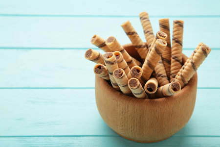 Coffee wafer stick roll with coffee cream in bowl on blue background. Space for text. top viewの写真素材