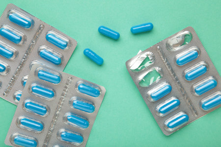 Blister pack with medicines on mint background, top view. Dietary supplements, vitamins for health...