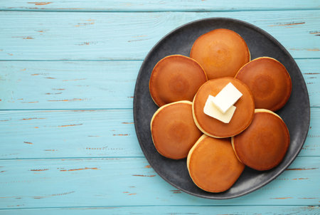 Homemade pancakes with butter in plate on blue background. top viewの写真素材