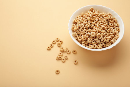 Bowl of sugar-coated corn flakes on beige background. top viewの写真素材