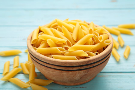Penne Rigate pasta in bowl on blue background. top viewの写真素材